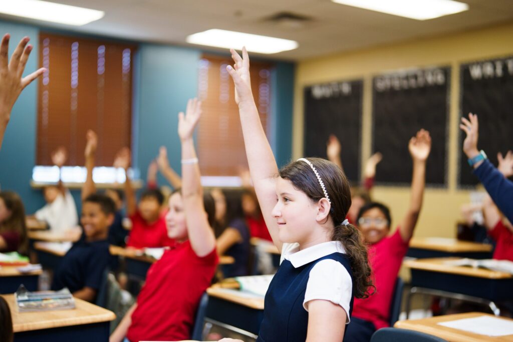 Students raise their hands to answer as a part of the Legacy Traditional Schools Legacy Gifted Program