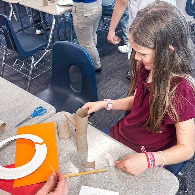 A student assembles a craft project at Legacy Traditional Schools